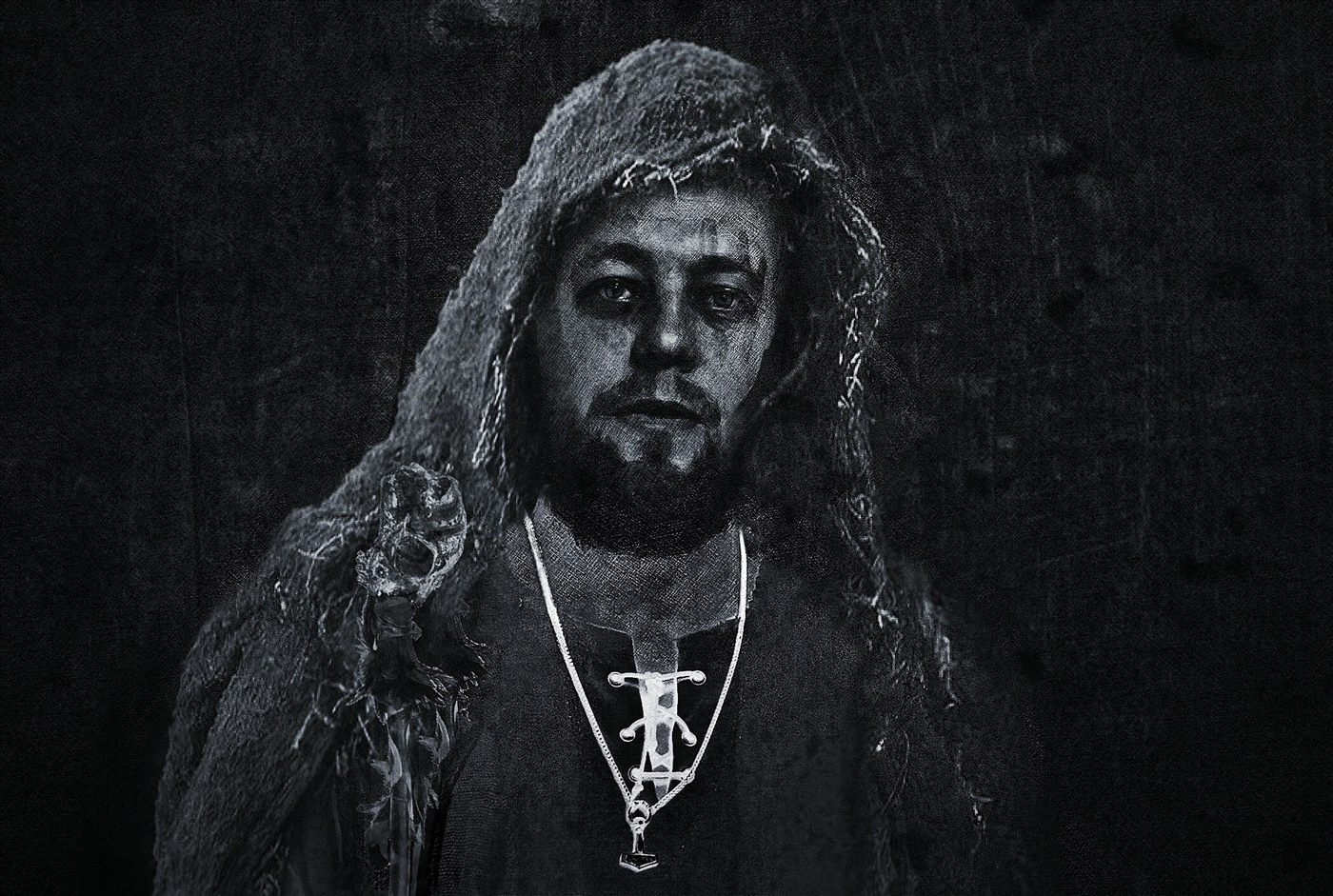 Danheim in a hooded cloak, holding a tagelharpa in darkness