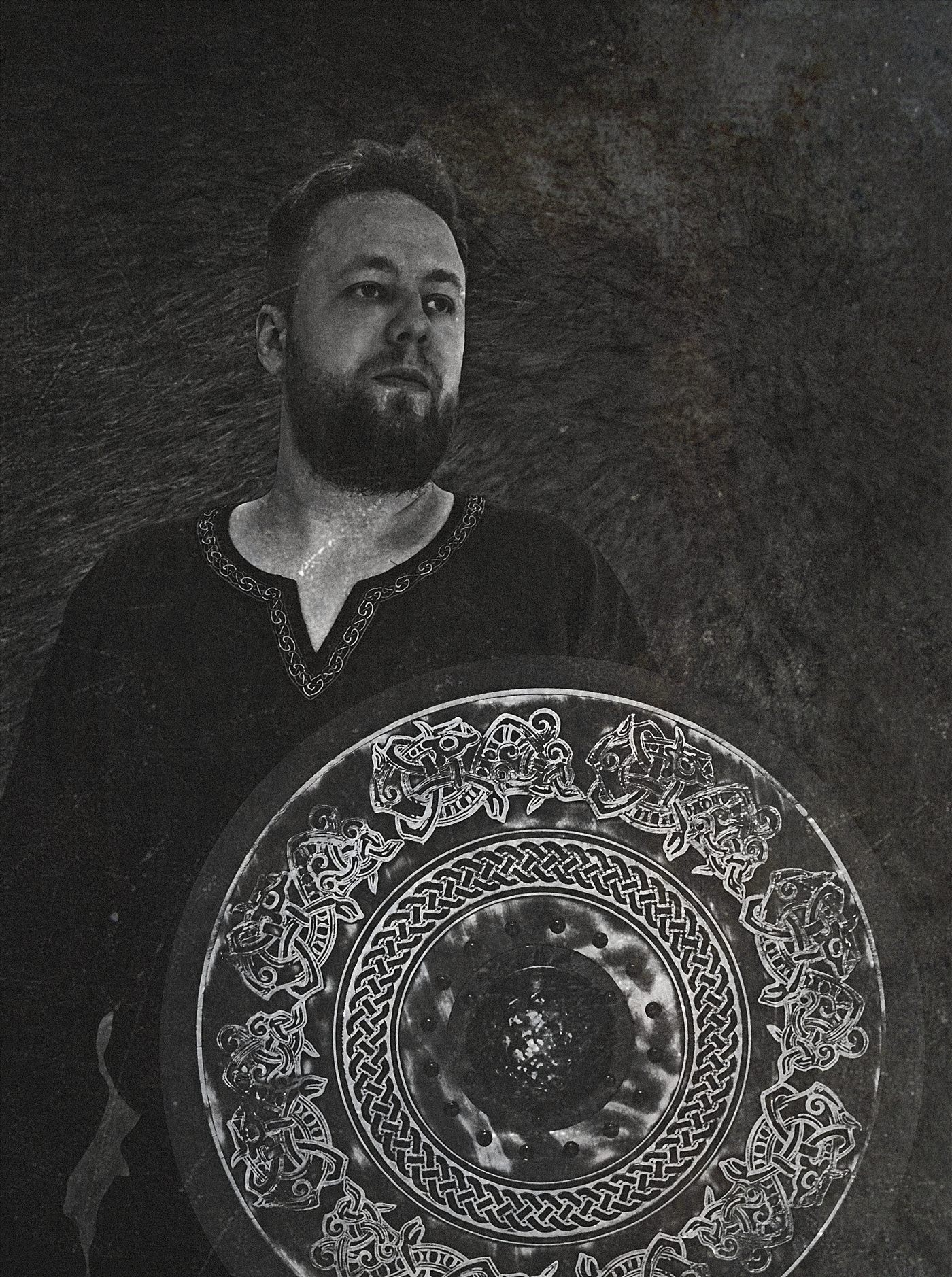 Danheim holding a carved Viking shield, black and white